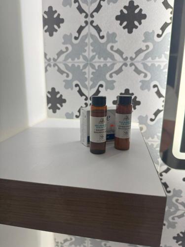 two bottles of paint sitting on a shelf in front of a wall at Blissful Bubali Apartment Aruba in Palm-Eagle Beach