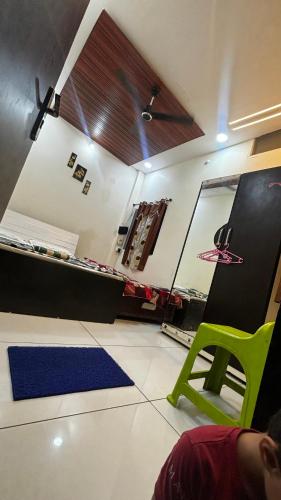 a room with a bed and a green chair at Shree nidhi comfort stay MAHAKAL ki krupa ujjain in Ujjain