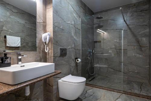 a bathroom with a toilet and a sink and a shower at Gold Palace SPA Resort Bukovel in Bukovel