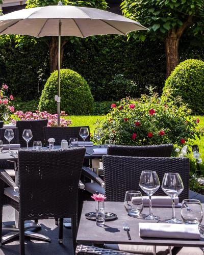 an outdoor table with wine glasses and an umbrella at Warwick Reine Astrid - Lyon in Lyon