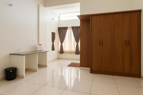 een keuken met een houten kast en een tafel bij Savi Service Apartments in Chikmagalūr