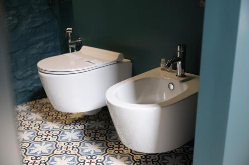 a bathroom with a white toilet and a sink at AD CALCEM Antiche Dimore Lagodentro in Terlizzi
