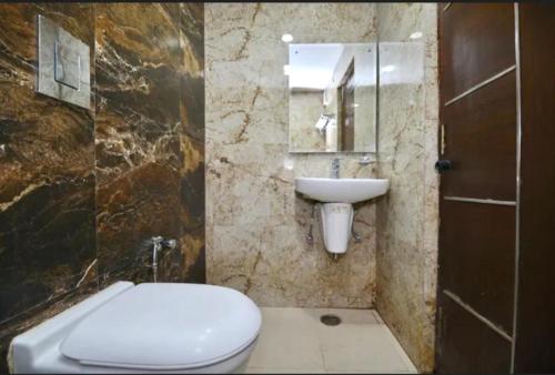 a bathroom with a white toilet and a sink at Hotel Star Pink' Couple friendly'Near rk ashram metro in New Delhi