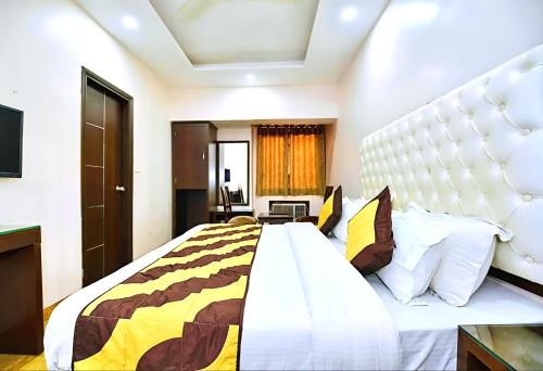 a bedroom with a large bed with a large headboard at Hotel Star Pink' Couple friendly'Near rk ashram metro in New Delhi