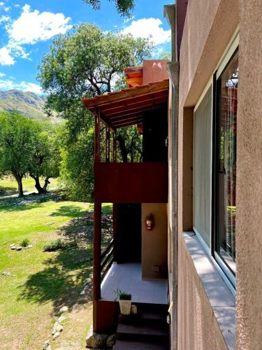a house with a porch with a view of a yard at Tata Inti Complejo Serrano in Merlo