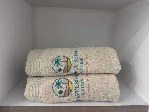 a stack of towels with a basketball on them at Blissful Bubali Apartment Aruba in Palm-Eagle Beach