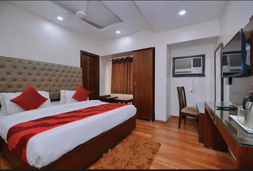 a hotel room with a large bed and a television at Hotel Star Pink' Couple friendly'Near rk ashram metro in New Delhi