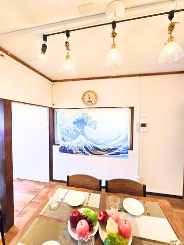 a dining room with a large painting on the wall at Osaka Riverside Inn in Neyagawa