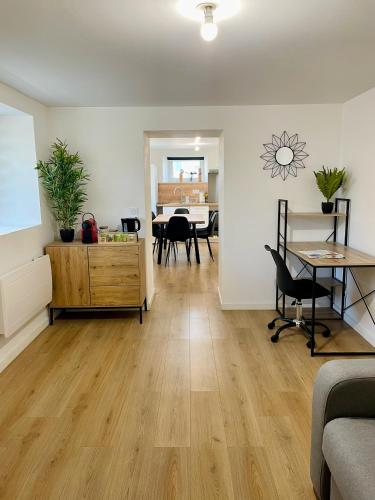 a living room with a table and a dining room at Appartement rénové avec parking facile in Hérimoncourt