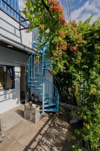 a blue staircase leading up to a building with flowers at Aluna Residence Homestay in Da Nang