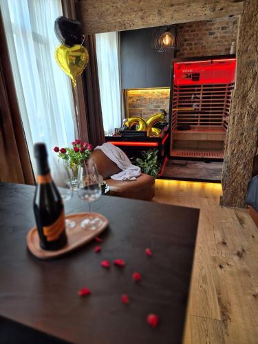 a bottle of wine and a glass on a table at Apartament Przy Murach in Toruń