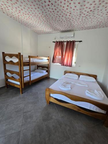 a bedroom with a bed and two bunk beds at Toska homes in Mullini i Danit