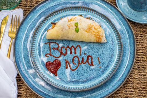 a blue plate with a piece of food on it at Hotel Boutique Bahia Bonita in Trancoso