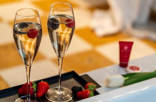 two glasses of champagne with fruit on a tray at Leonardo Hotel Milan City Center in Milan