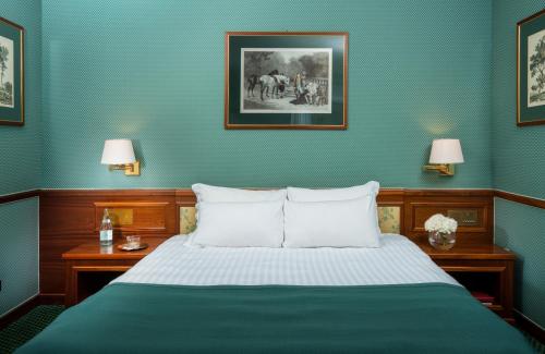 a bedroom with a bed with two tables and two lamps at Leonardo Hotel Milan City Center in Milan