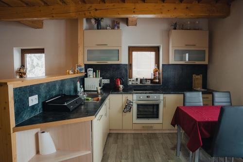 a small kitchen with a counter top and a table at Chalúpka pod lesom Zázrivá in Zázrivá
