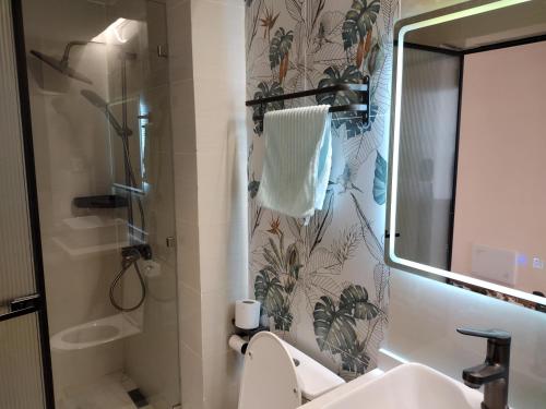 a bathroom with a toilet and a sink and a mirror at Lenayan at Artesano in Nairobi