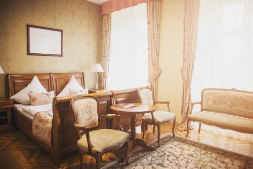 a bedroom with a bed and a table and chairs at Pałac Brunów - Wellness & SPA in Lwówek Śląski