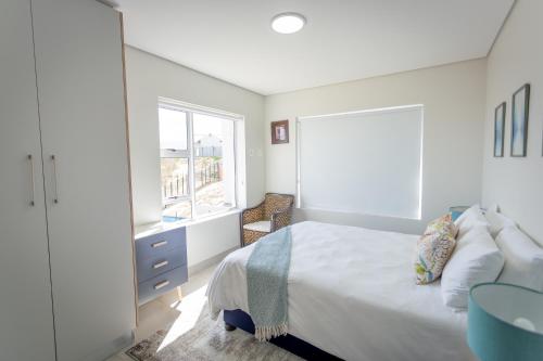 a white bedroom with a bed and a window at Luxury Apartment - Apartment 44 - 1 On York in George
