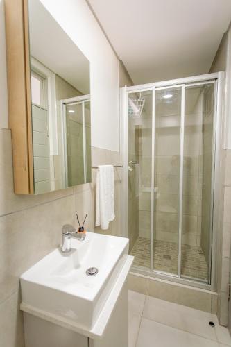 a white bathroom with a sink and a shower at Luxury Apartment - Apartment 44 - 1 On York in George
