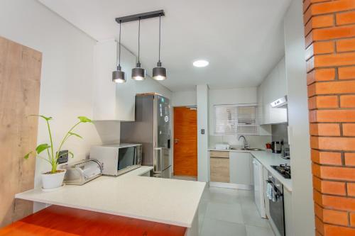 a kitchen with white appliances and a brick wall at Luxury Apartment - Apartment 44 - 1 On York in George