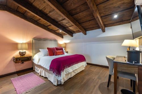 a bedroom with a large bed and a desk at Casa Faustina Boutique Hotel in Antigua Guatemala