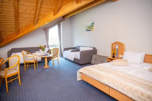 a hotel room with two beds and a table and chairs at Hotel Bessunger Forst in Roßdorf