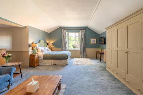 a bedroom with a bed and a couch and a window at Llanerchydol Hall Suites in Welshpool