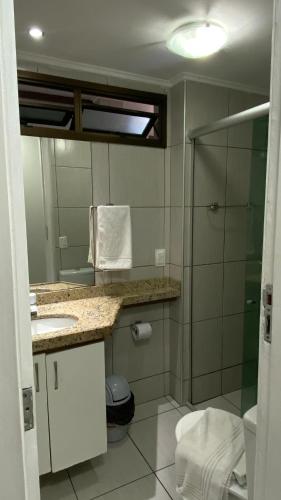 a bathroom with a shower and a sink and a mirror at Flat Vista Mar - Fortaleza in Fortaleza