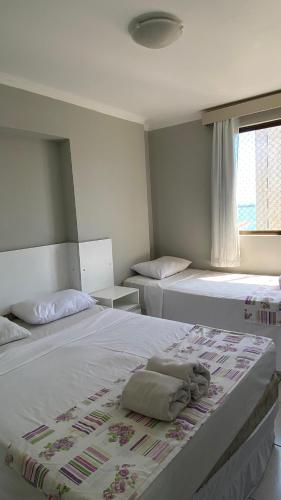 a bedroom with two beds and a window at Flat Vista Mar - Fortaleza in Fortaleza