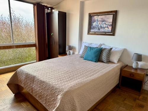 una camera da letto con un letto e una grande finestra di Departamento mirador en Villa Florita, la mejor vista de La Paz a La Paz