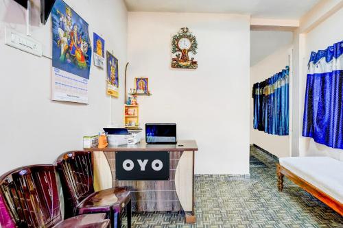 a room with chairs and a desk with a laptop at Hotel O Enclave Stayz Inn in Chennai