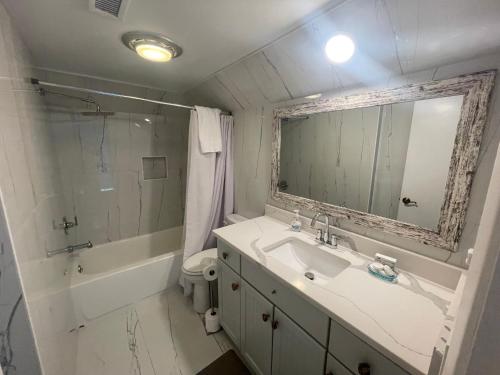 シーブルック・アイランドにある758 Spinnaker Beach Houseの洗面台、鏡、浴槽のあるバスルーム