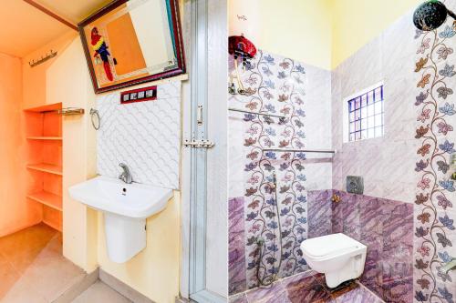 a bathroom with a toilet and a sink and a shower at Hotel O Enclave Stayz Inn in Chennai