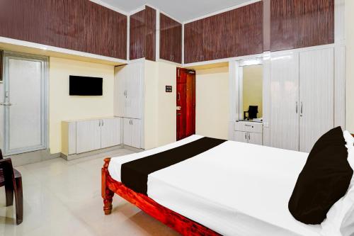 a bedroom with a bed and a tv in it at Hotel O Enclave Stayz Inn in Chennai