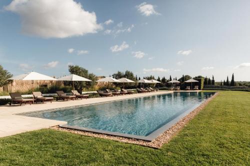 カラン・ポルテルにあるTorralbenc, a Small Luxury Hotel of the Worldの椅子とパラソルのある大きなプール