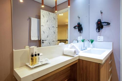 a bathroom with a sink and a mirror at Hampton Park São Paulo Jardins in Sao Paulo