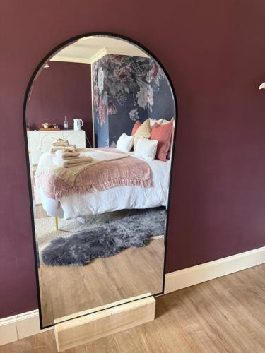 a bedroom with a bed and a large mirror at The Salt house in Golspie