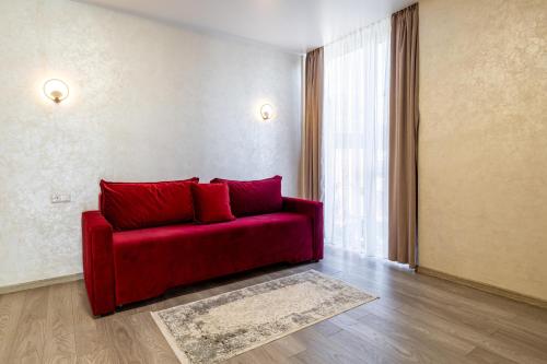a red couch in a living room with a window at Gold Palace SPA Resort Bukovel in Bukovel