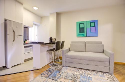 a living room with a couch and a kitchen at Hampton Park São Paulo Jardins in Sao Paulo