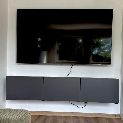 a flat screen tv hanging on a wall at Apartmenthaus Gilden 1 in Borken