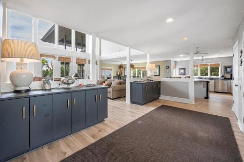 a large kitchen and living room with blue cabinets at Southern Dunes home by Peace Vacations in Georgetown
