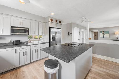 a kitchen with white cabinets and a black counter top at Southern Dunes home by Peace Vacations in Georgetown
