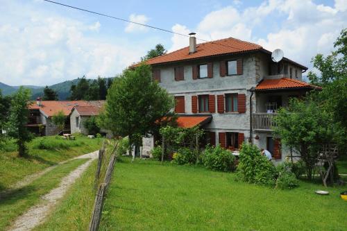 a house with a grass yard in front of a house at Holiday Farmhouse Skvor in Robidišče