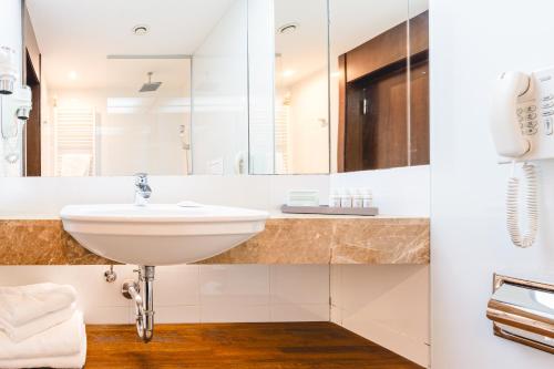a bathroom with a sink and a mirror at Hotel International in Sinaia