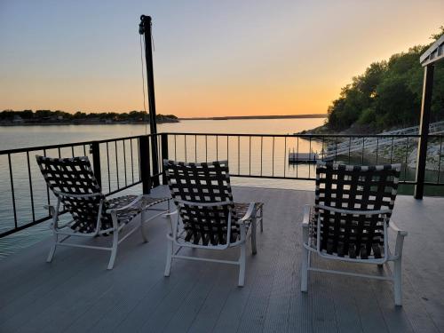 three chairs sitting on a deck with a view of the water at The Lookout At Lakewood, By M Host in Bridgeport
