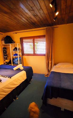 a bedroom with two beds and a window at Casa Josuá in Nísia Floresta
