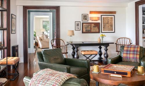 a living room with green chairs and a table at Pickering House in Wolfeboro