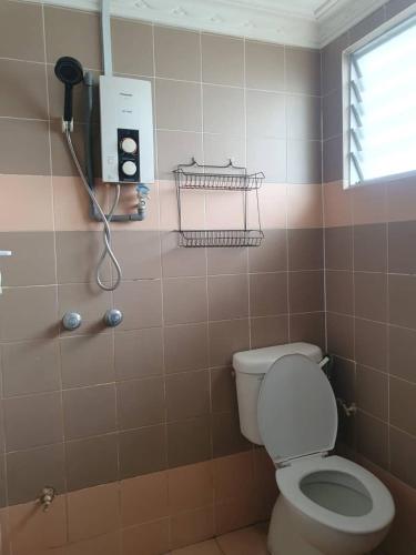 a bathroom with a toilet and a phone on the wall at Port Dickson Sunshine Resort in Port Dickson