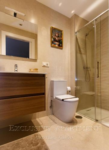 a bathroom with a toilet and a shower and a television at Exclusive Apartment Center Gijón in Gijón